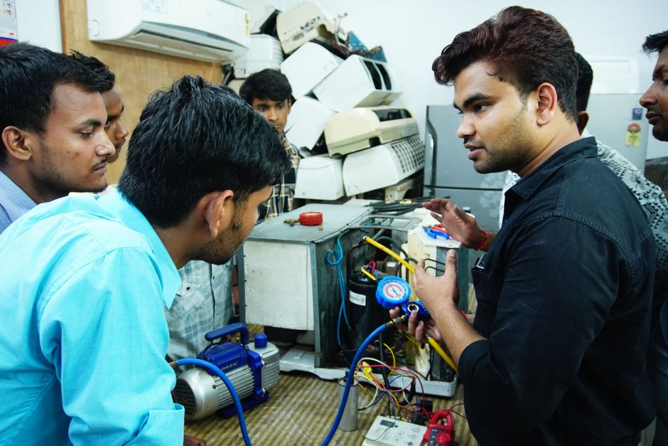Automotive technician servicing vehicle air conditioning