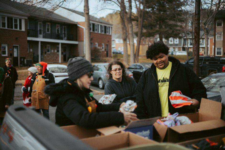 Volunteers distributing holiday food vouchers and toys to families