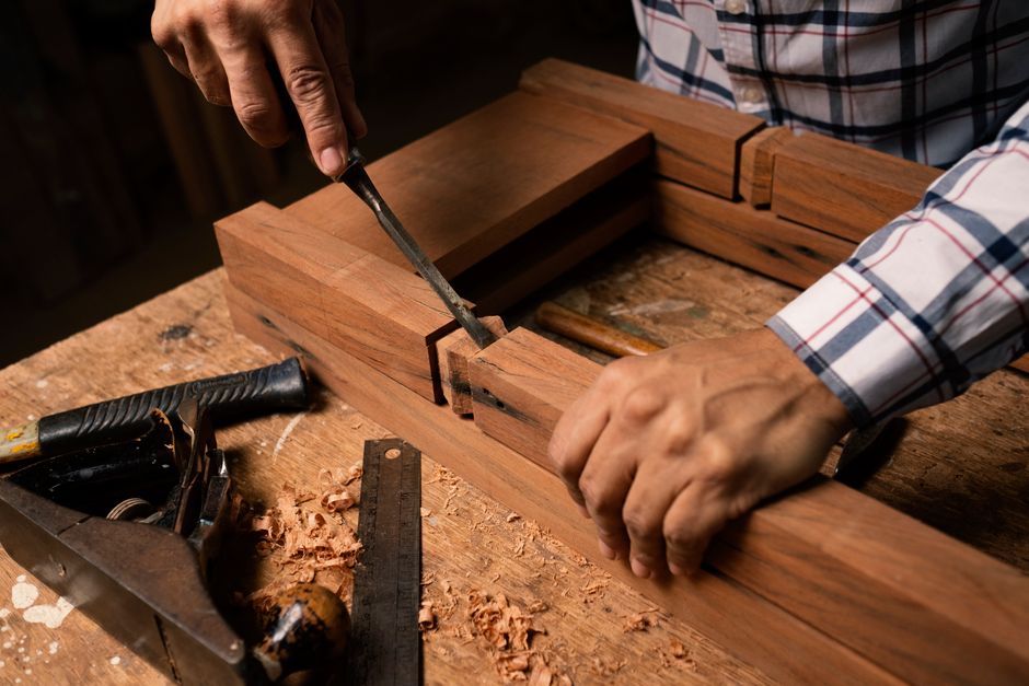 Craftsman installing intricate wood trim and moldings