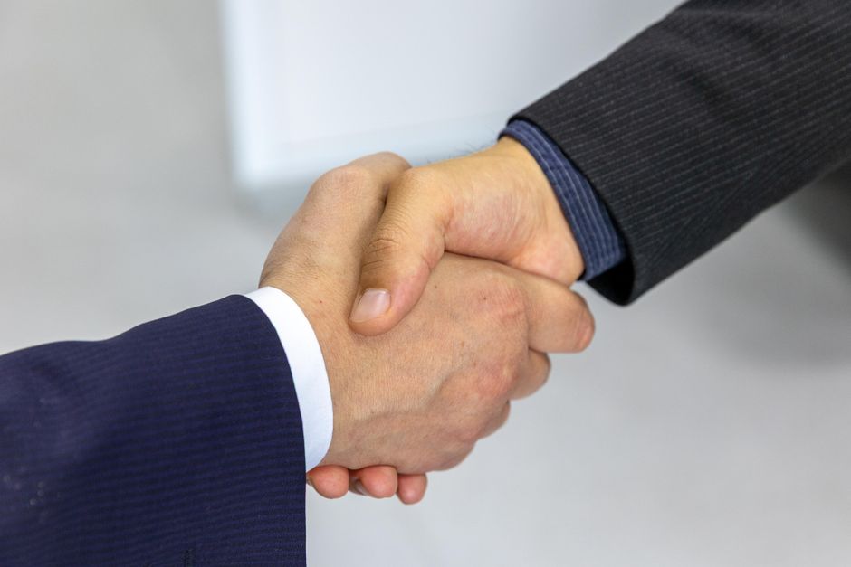 Family business owners and advisor shaking hands after agreement