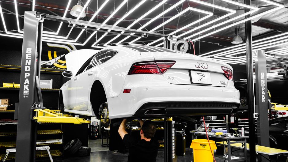 Technician performing scheduled maintenance on Audi