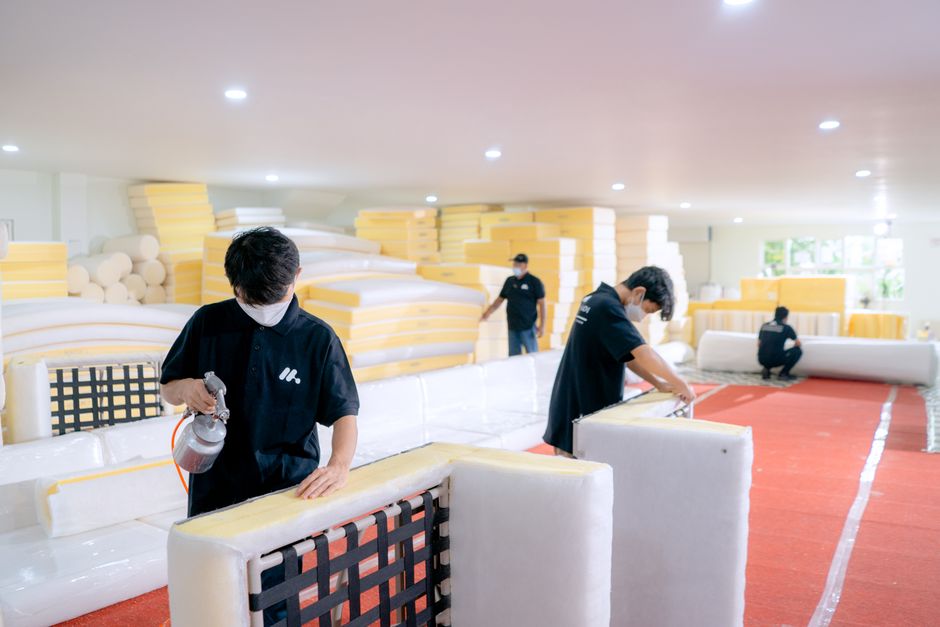 Artisans upholstering furniture in a woodworking workshop