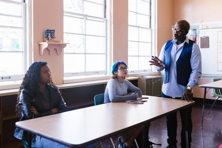 A teacher providing individualized support to a high school student