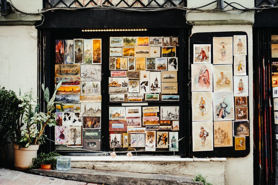 Art gallery interior displaying local paintings and prints.