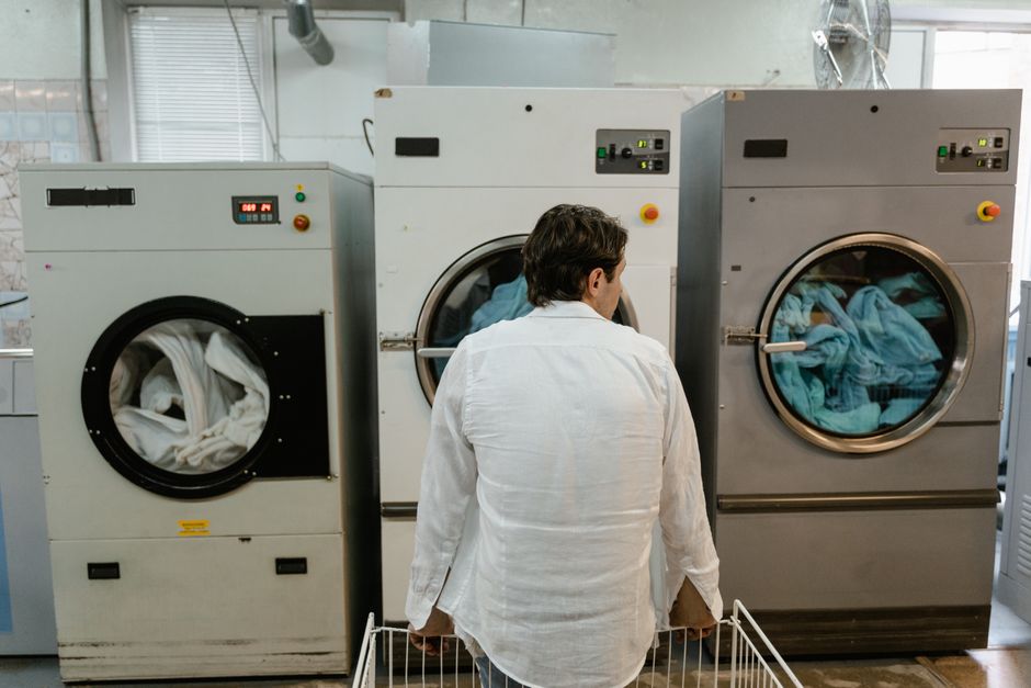 Large volume of linens and towels stacked on carts in a commercial laundry setting.