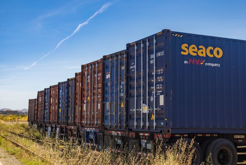 Freight train transporting shipping containers across landscape