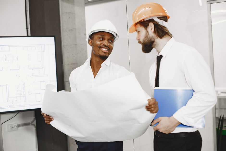 Construction team discussing blueprints during a site meeting
