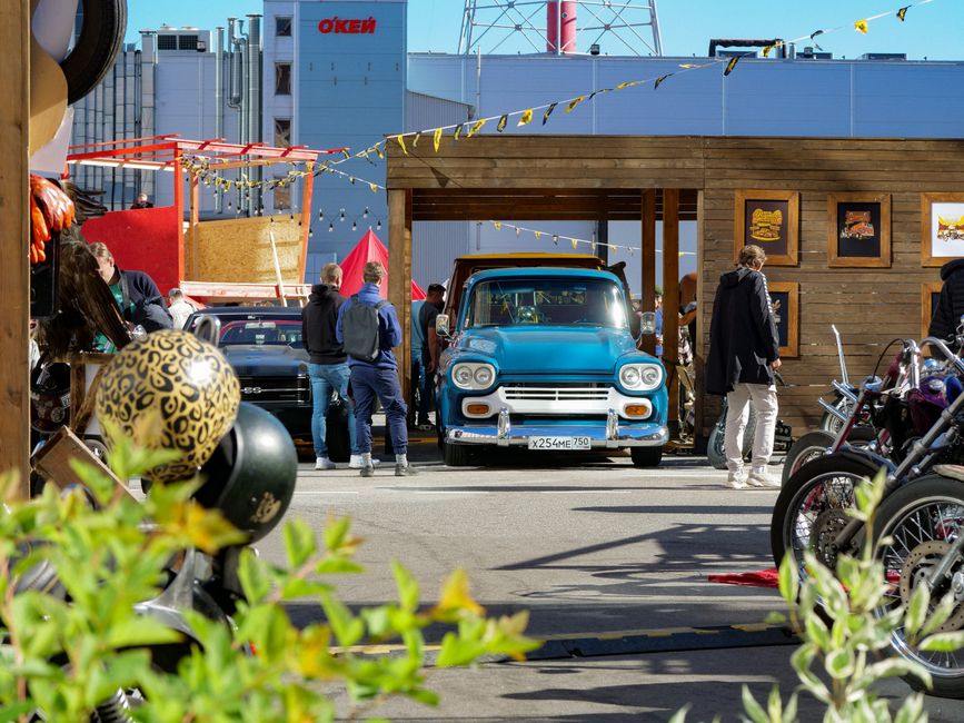 Group of automotive enthusiasts with cars and motorcycles