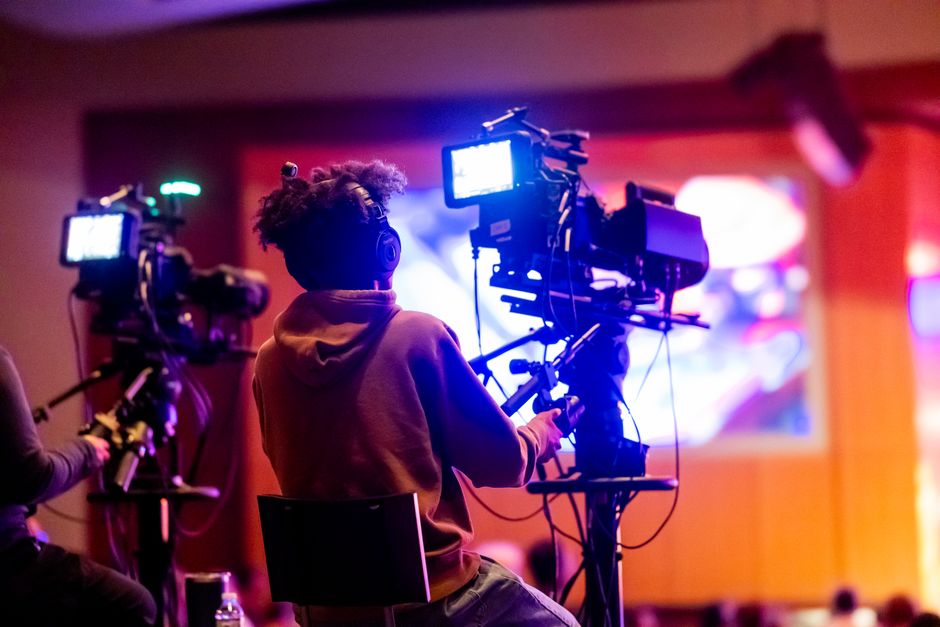 Media project manager coordinating with TV production crew