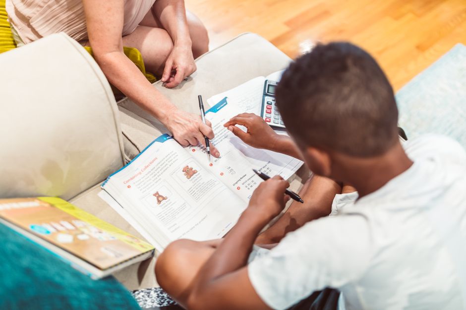 Tutor guiding a student through advanced math problems in a classroom setting