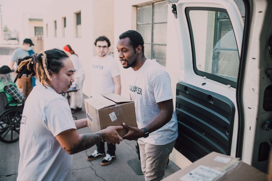 A group of volunteers assisting local residents in an outdoor community setting