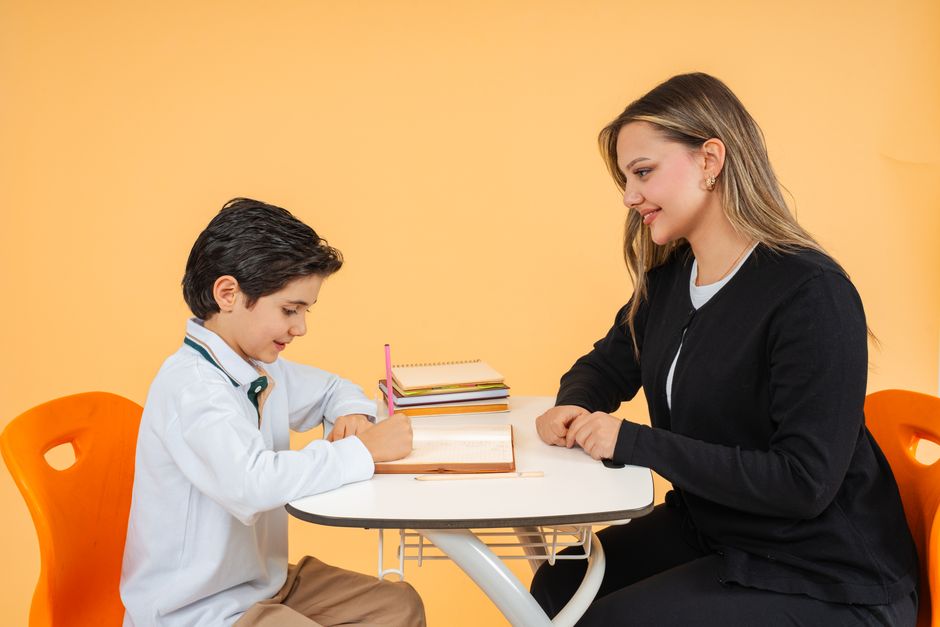 A mentor guiding a young student during a one-on-one learning session.
