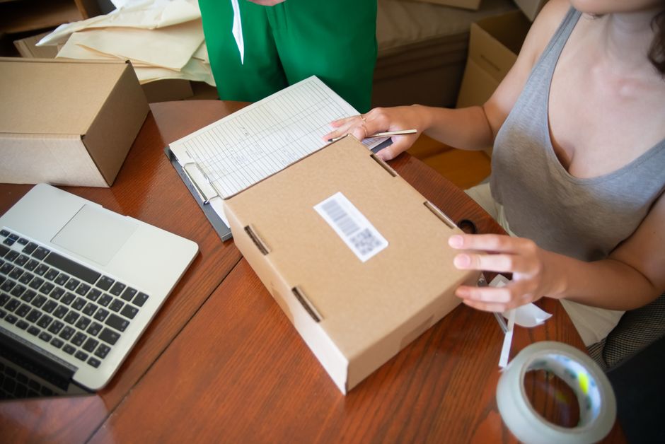 A friendly woman packing lingerie products for online shipping in a modern workspace