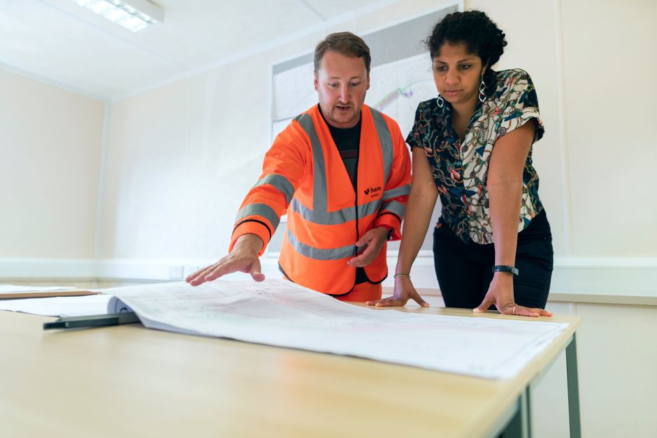 Team of construction professionals, architects, and designers collaborating on site